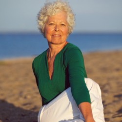 Senior woman enjoying yoga on the beach