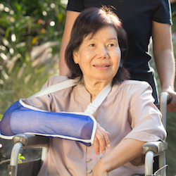Asian senior woman with broken wrist on wheel chair