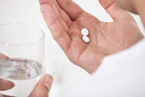 Man Taking Pills With Glass Of Water