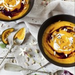 cream of pumpkin and purple carrot soup on two black japanese bowls with sour cream